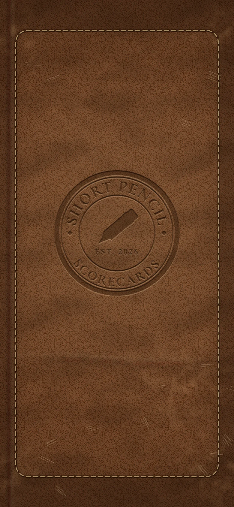 Short Pencil opening on its leather cover, the crest pressed into the grain: Short Pencil Scorecards, established 2026